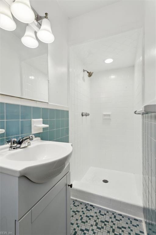 bathroom featuring tile walls, vanity, and tiled shower