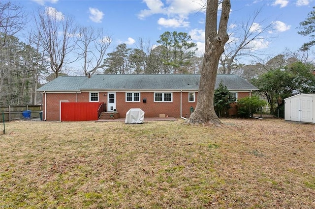 rear view of house featuring a storage unit and a lawn