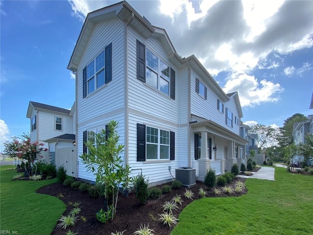 view of side of home featuring covered porch, central air condition unit, and a yard