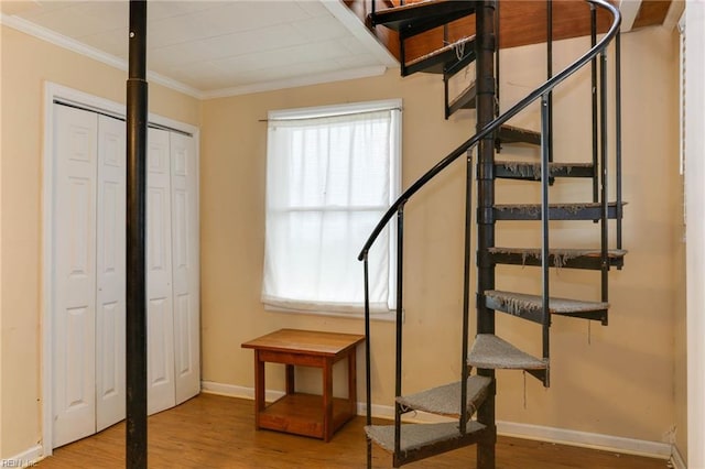 staircase with ornamental molding and wood-type flooring