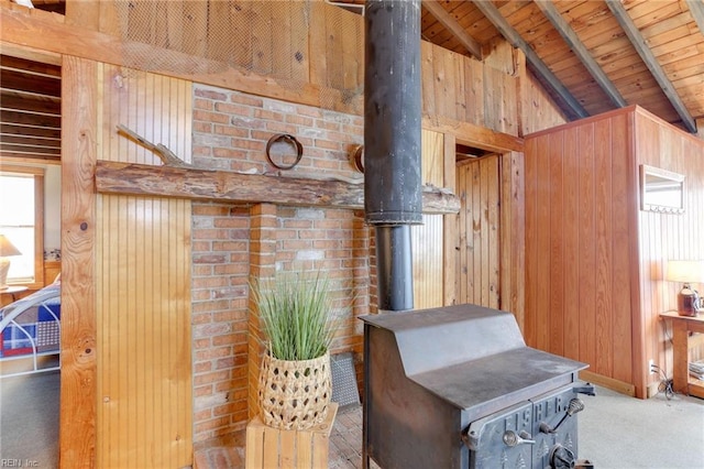 interior details with wood ceiling, a wood stove, wooden walls, and beam ceiling