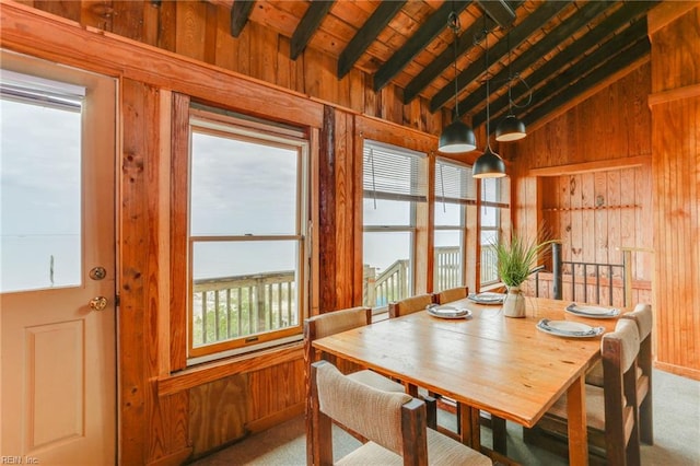 dining area with wooden ceiling, carpet, lofted ceiling with beams, and wooden walls