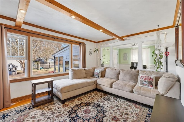 living room featuring decorative columns, hardwood / wood-style floors, crown molding, and beam ceiling