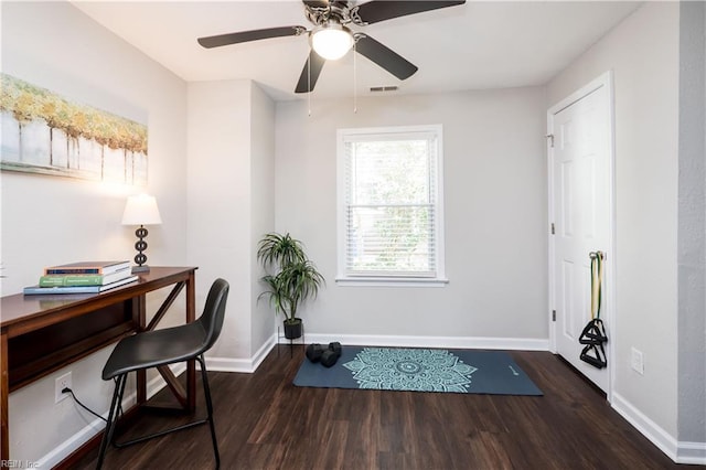 office featuring a ceiling fan, visible vents, dark wood finished floors, and baseboards