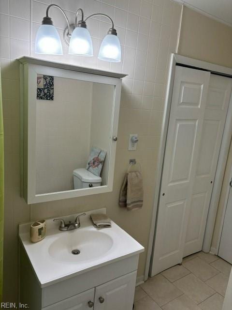 bathroom featuring toilet, tile patterned flooring, and vanity