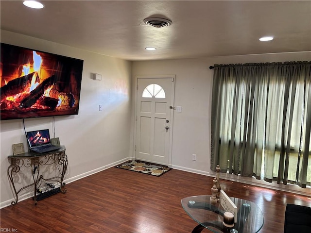 foyer entrance with dark hardwood / wood-style flooring and a fireplace