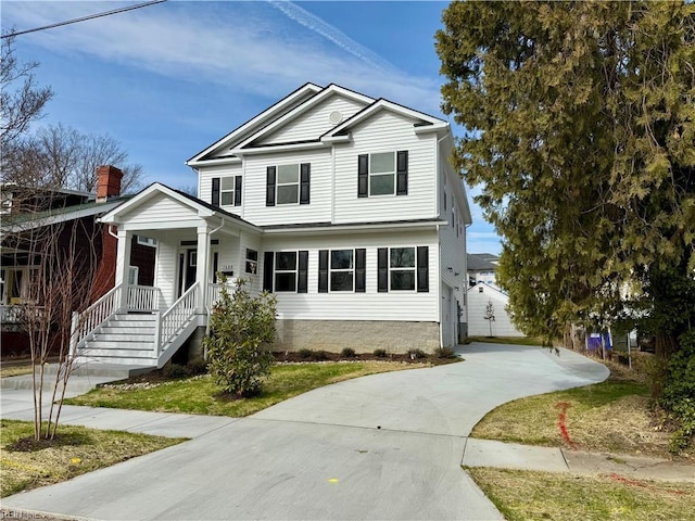 view of front facade with concrete driveway and a porch