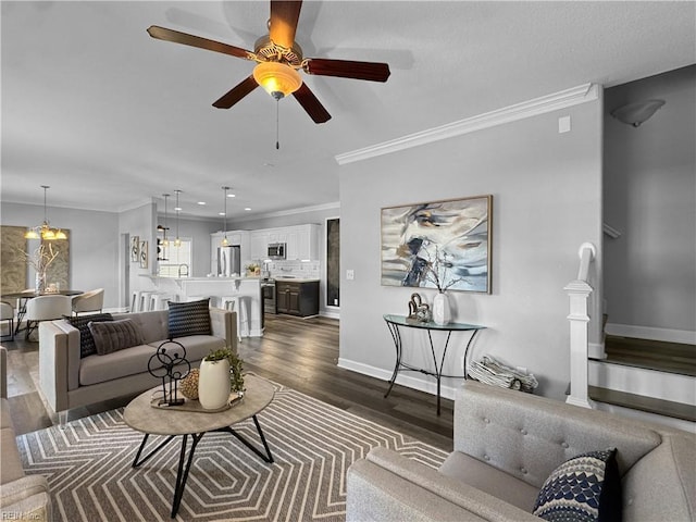 living room featuring ceiling fan with notable chandelier, crown molding, and dark hardwood / wood-style flooring