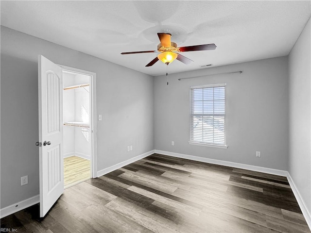 unfurnished room featuring ceiling fan and dark hardwood / wood-style flooring