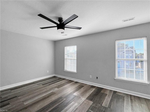 spare room with ceiling fan, a textured ceiling, and dark hardwood / wood-style flooring