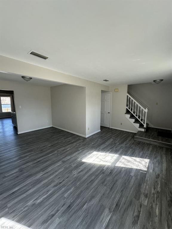 unfurnished living room with dark wood-type flooring