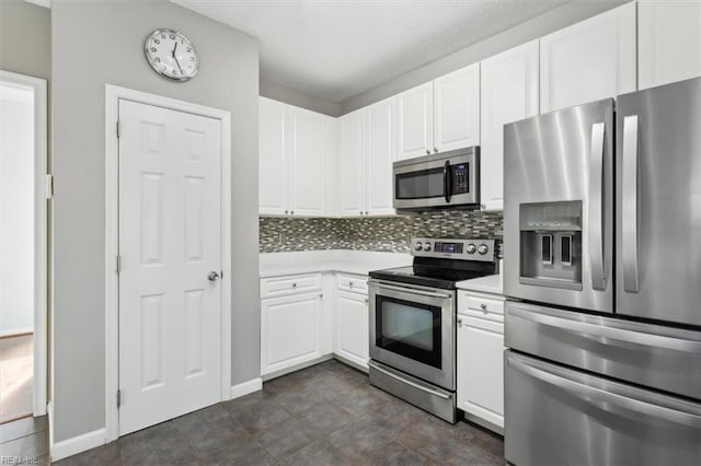 kitchen featuring stainless steel appliances, white cabinetry, and backsplash