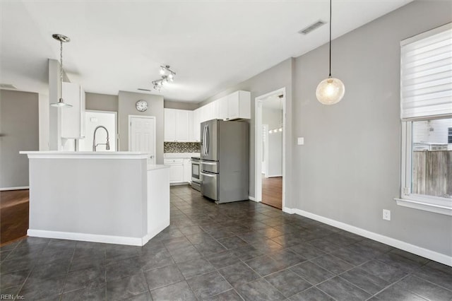 kitchen with stainless steel appliances, sink, backsplash, white cabinets, and pendant lighting