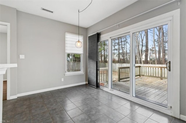 unfurnished dining area featuring dark tile patterned flooring