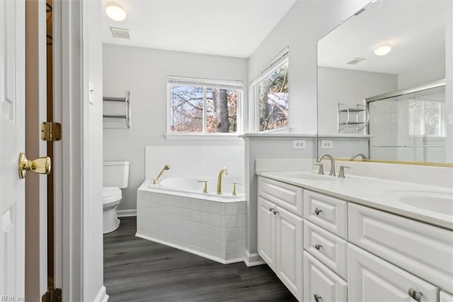 full bathroom with toilet, hardwood / wood-style flooring, plus walk in shower, and vanity