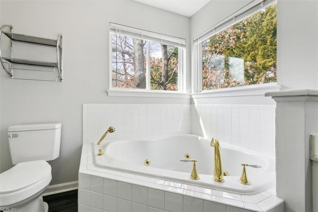 bathroom featuring a relaxing tiled tub and toilet