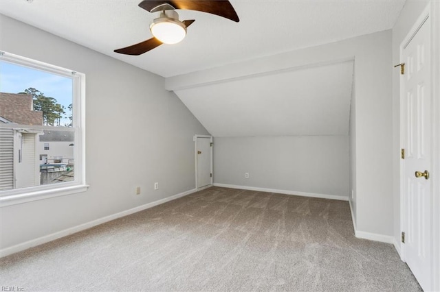 additional living space with carpet floors, ceiling fan, and lofted ceiling with beams