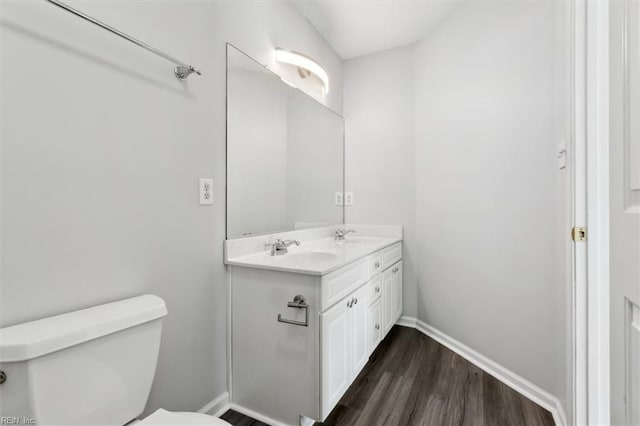 bathroom with toilet, hardwood / wood-style flooring, and vanity