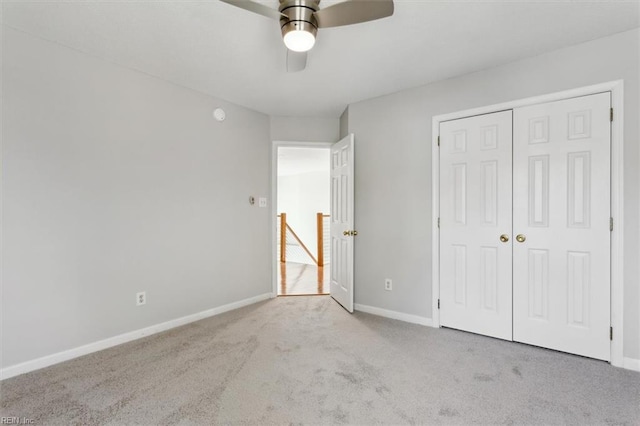 unfurnished bedroom with a closet, light colored carpet, and ceiling fan