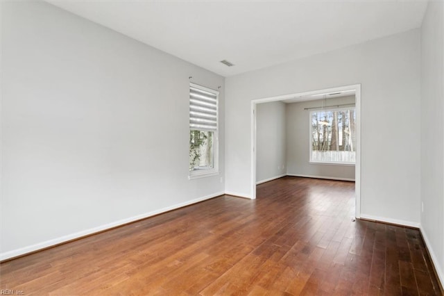 unfurnished room featuring hardwood / wood-style flooring and a notable chandelier