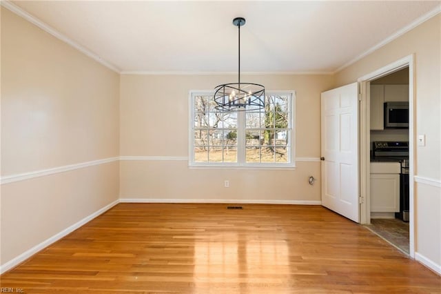 unfurnished dining area with light wood-type flooring, an inviting chandelier, baseboards, and crown molding