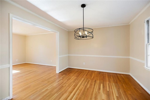 unfurnished room with ornamental molding, light wood finished floors, and baseboards