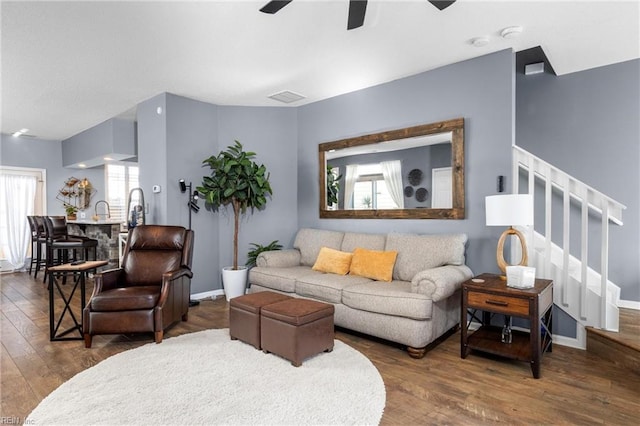 living room with ceiling fan and dark hardwood / wood-style flooring