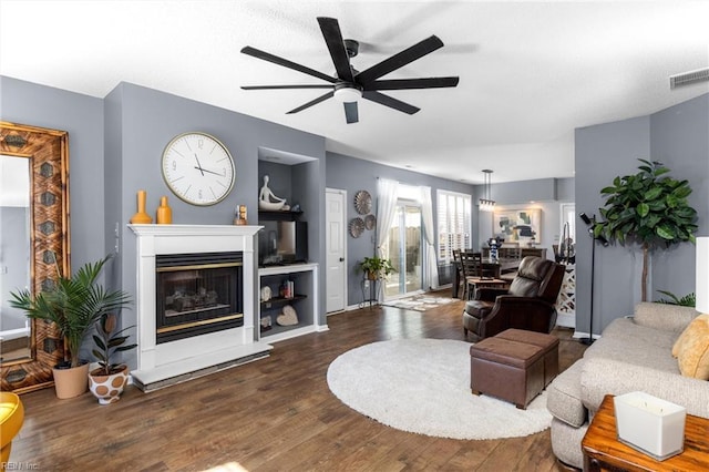 living room with ceiling fan and dark wood-type flooring