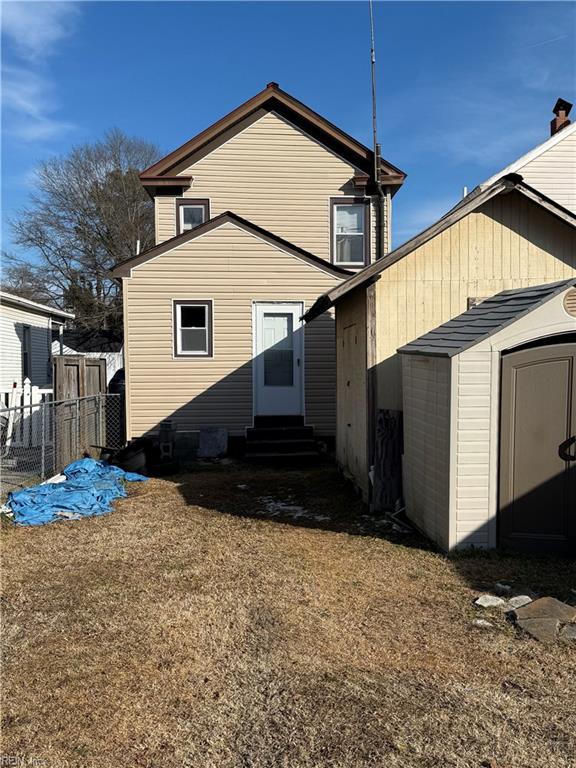 rear view of property with a storage shed