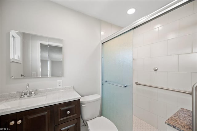 bathroom with toilet, an enclosed shower, and vanity