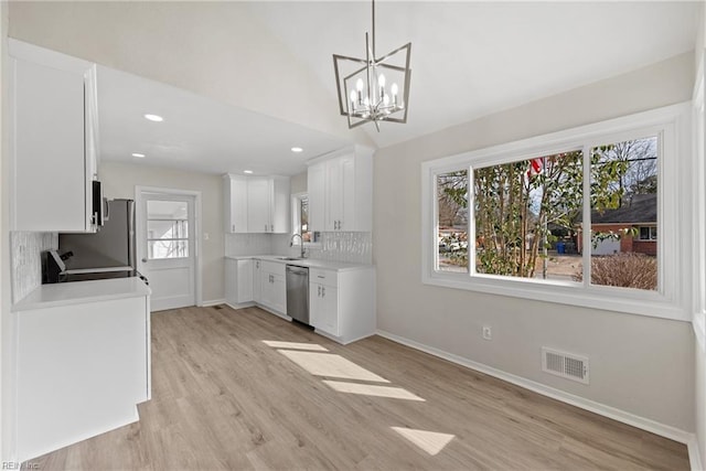 kitchen with stove, sink, backsplash, stainless steel dishwasher, and white cabinets