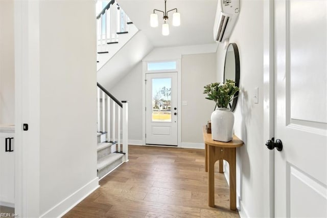 foyer featuring light wood-type flooring, vaulted ceiling, and a chandelier