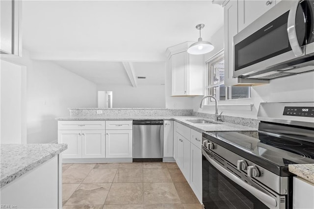 kitchen featuring a sink, white cabinets, appliances with stainless steel finishes, light stone countertops, and pendant lighting