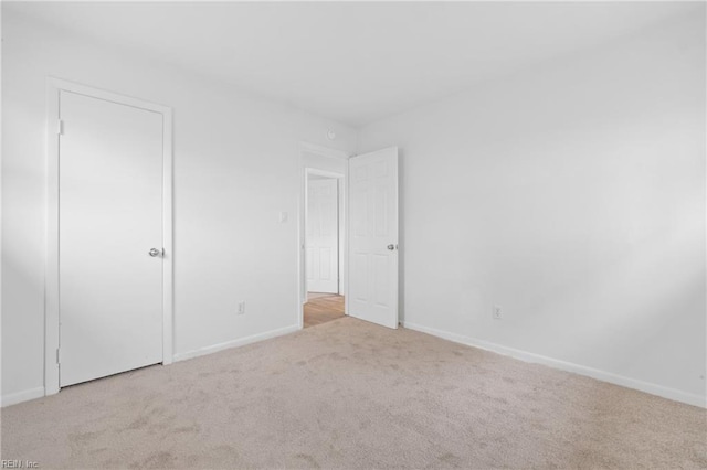 unfurnished bedroom with light carpet and baseboards