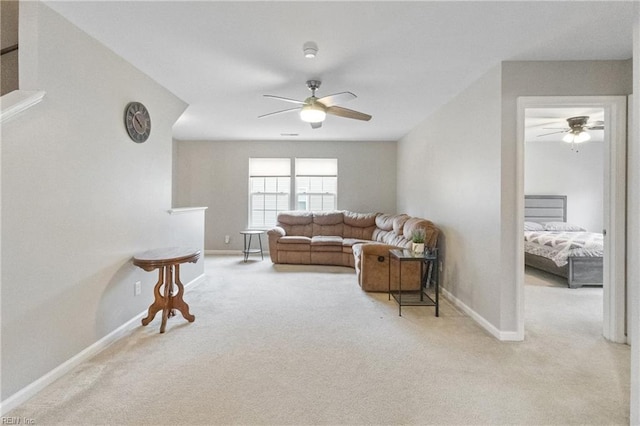 living room featuring light carpet, ceiling fan, and baseboards