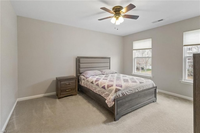 bedroom featuring light carpet, multiple windows, and baseboards