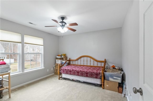 carpeted bedroom with a ceiling fan, visible vents, and baseboards