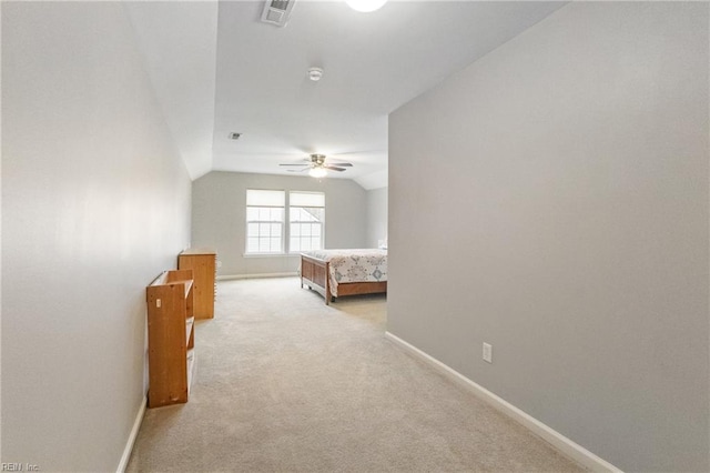 unfurnished bedroom featuring light carpet, baseboards, visible vents, and lofted ceiling