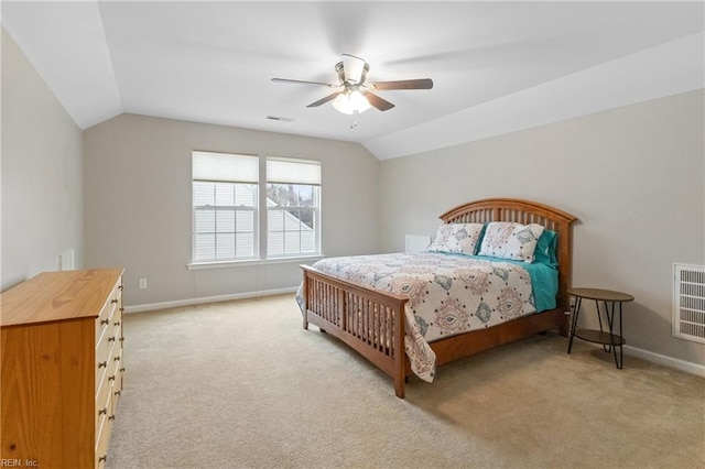 bedroom with lofted ceiling, light colored carpet, visible vents, and baseboards