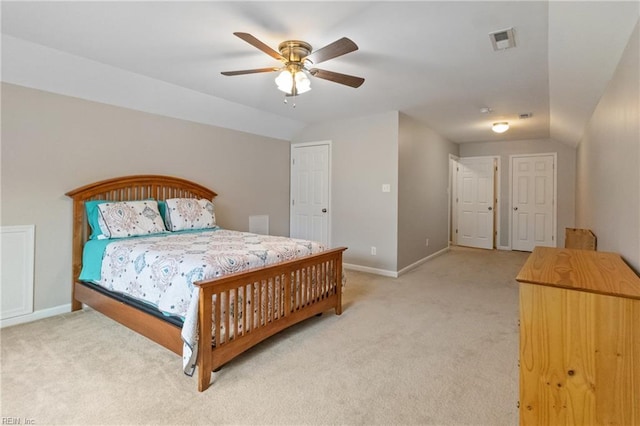 bedroom featuring light carpet, vaulted ceiling, and visible vents