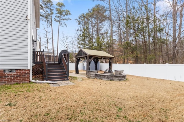 view of yard featuring a fenced backyard, stairway, a wooden deck, and a gazebo