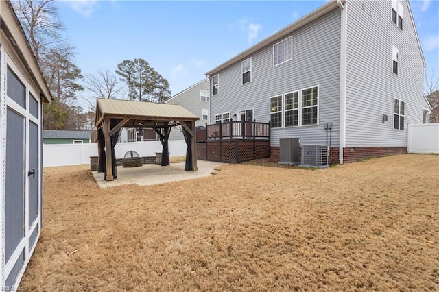 rear view of property with cooling unit, a fenced backyard, a gazebo, a lawn, and a patio area