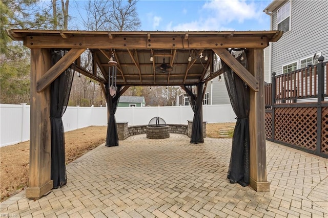 view of patio / terrace featuring a fenced backyard, a fire pit, ceiling fan, and a gazebo