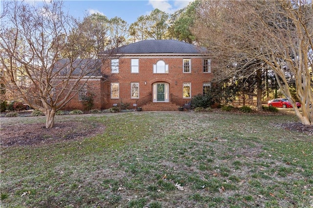 view of front of home featuring brick siding and a front lawn