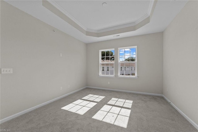 unfurnished room with a tray ceiling, ornamental molding, and light carpet