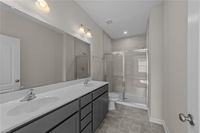 bathroom featuring toilet, a shower with door, and vanity