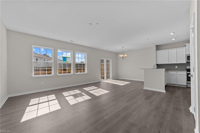 unfurnished living room with dark hardwood / wood-style floors and a chandelier