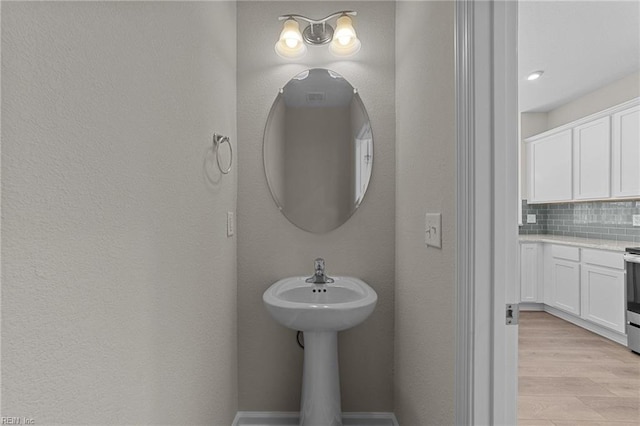 bathroom with backsplash and hardwood / wood-style floors