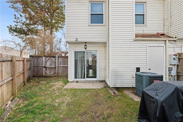 back of property with central AC unit, a lawn, and a patio area