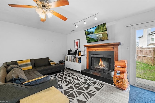 living room featuring hardwood / wood-style flooring, ceiling fan, and rail lighting